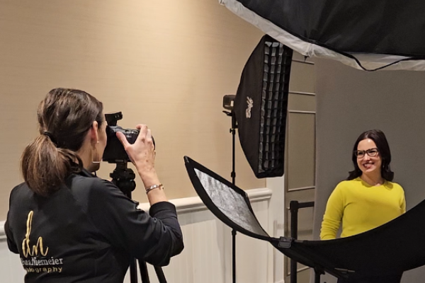 Photographer creating professional business portraits at an on-site corporate event studio.