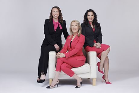 Three-woman professional team portrait in coordinated business attire